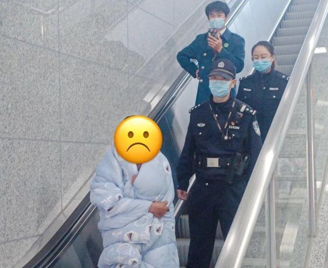 杭州地铁站口 男子裹被子偷地铁警示牌卖废品换钱 为啥这样干？
