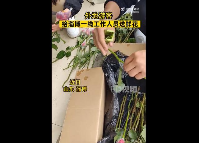 游客给淄博工作人员送花：给他们打气加油